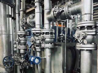 Old rusty industrial valves and metal pipes with peeling paint and corrosion, showcasing aged mechanical components in a vintage utility room. Close-up shot with natural lighting.
