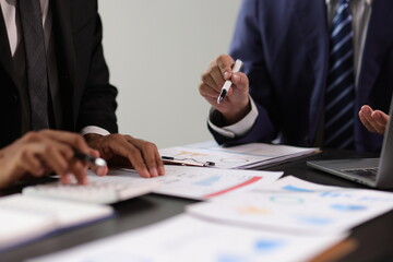 Businessman and financial advisor analyzing financial charts and graphs on document during meeting....