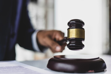 Lawyer holding gavel in courtroom making decision on legal case, symbolizing the legal profession...