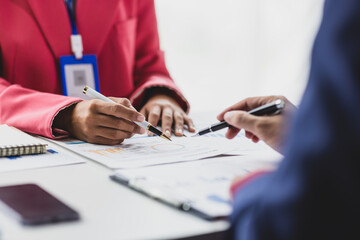 Business consultant analyzing financial data on report with charts and graphs. Business colleague...