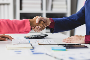 Business professionals are shaking hands after a successful meeting.