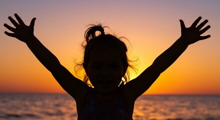 Silhouette of a young girl with her arms raised against a sunset and ocean background, suggesting joy and freedom.