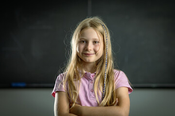 Confident elementary student smiling with crossed arms