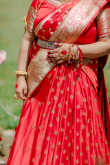 Vibrant Red Attire: Traditional garment featuring rich textures and gold detailing, embodying...