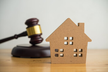 House model with hammer judge gavel background on table. Asset forfeiture, foreclosure, bankruptcy,...