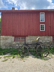 Red Barn with Historic Horse Carriage in Rural Setting