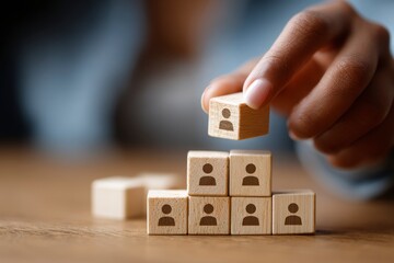A person is holding a wooden block with a person on it and is about to break it. Concept of breaking down barriers or hierarchies, possibly in a workplace or social setting