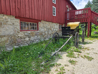 Red Barn with Historic Horse Carriage in Rural Setting