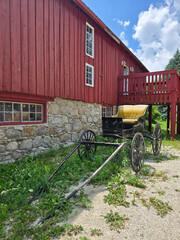 Red Barn with Historic Horse Carriage in Rural Setting