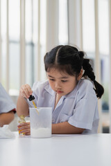 Young Girl Conducting Science Experiment in Laboratory, Mixing Ingredients with Dropper, Curious Expression, Educational Setting, Child Learning Science