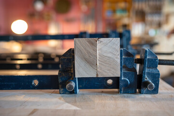 Wooden beams pressed together with clamps to form large board after sanding and gluing surfaces....