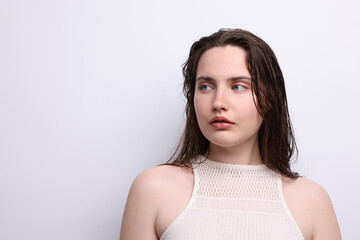 Beautiful woman with natural skin complexion on light grey background. Space for text