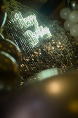 Decoration as a background for photography with white and gray balloons, glitter, neon sign Happy Birthday in England and a large number eighteen that has led lighting
