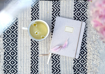 Chamomile tea and notebook - calm morning scene. Slow living, journaling, mindfulness and peaceful...