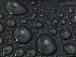 Macro Shot of Water Droplets on Dark Textured Surface.