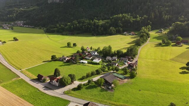 Scenic Aerial View of Swiss Train Passing Through Alpine Valley with Green Fields and Mountains Near Flums, Berschis and Walenstadt, Switzerland &ndash; Drone Footage
