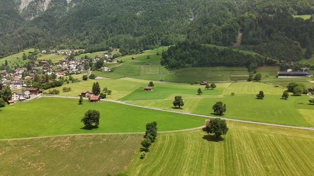 Scenic Aerial View of a Valley with Green Fields and Mountain Landscape in Switzerland near Flums, Berschis, and Walenstadt in the Canton of St. Gallen &ndash; Drone Footage