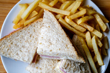 Homemade Ham and Cheese Sandwich In Sliced Brown Bread With Chips Or Fries