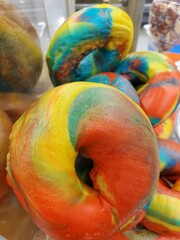 Closeup of a rainbow bagel with bright colors and intricate patterns.