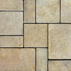 Natural beige stone marble tiles in square and rectangular pattern. Outdoor textured honed tiles in yellow and beige color with black grouts. Wall or floor tiles seamless background texture.