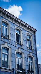 A charming blue French house with white shutters and blue shutters, bathed in sunlight