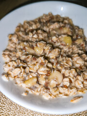 Oatmeal with banana and chia seeds in a white bowl for healthy breakfast