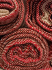 Rolled woolen textiles with red and beige patterns