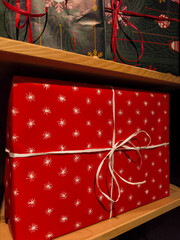 Festive red gift box with white ribbon on shelves