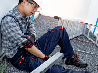 Accident and injury at work. Male worker with protective workwear got injured by broken arm at...