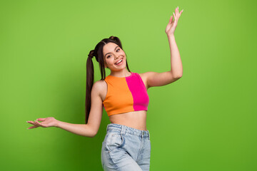 Young cheerful woman posing on a vibrant green background in trendy outfit, vibrant hairstyle,...
