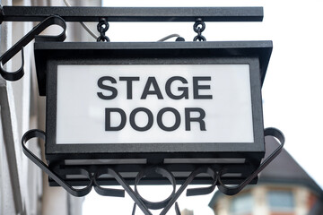 Low angle view of overhead stage door sign on exterior of theatre building.