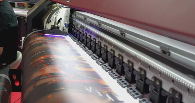 Large format printer printing a colorful image on white vinyl