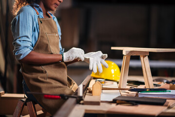 Factory Worker African American Woman Carpenter Preparing for Work with Safety Gear and Gloves in...