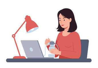 Woman at desk pumping breast milk with laptop under lamp