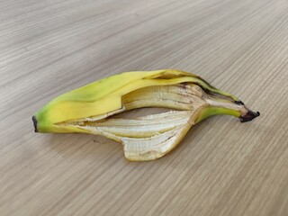 Partially peeled banana on light brown wooden table. Suitable for food blogs, healthy lifestyle...