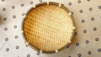 A small bamboo basket on floral linen background