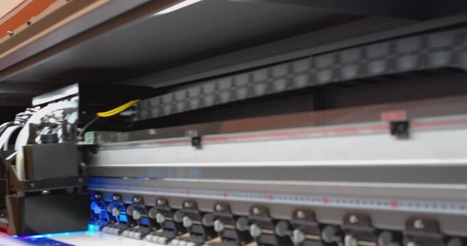 Large format printer printing a colorful image on white vinyl