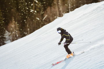 Close up freeze motion skier wearing helmet goggles carving on downhill looking at camera snowy...