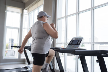 Man running on treadmill in gym. Mature male running on treadmill machine. Fitness, gym and exercising