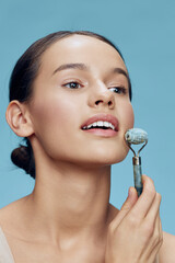 Young woman using jade roller for skincare, promoting healthy beauty routines and skincare rituals...