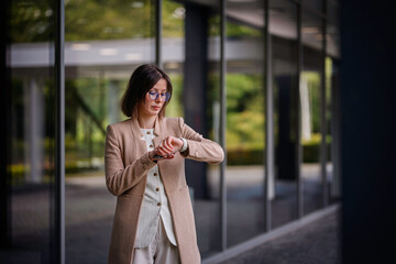 Businesswoman Checking Time on Smartwatch Outdoors