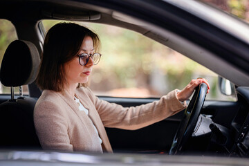 Focused Woman Driving Car in Business Attire