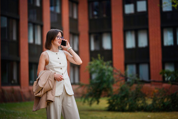 Obraz premium Businesswoman Talking on Phone Near Office Building
