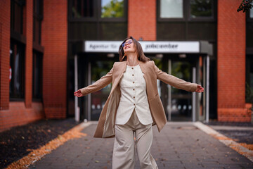 Joyful Woman Spinning Outside Jobcenter Building
