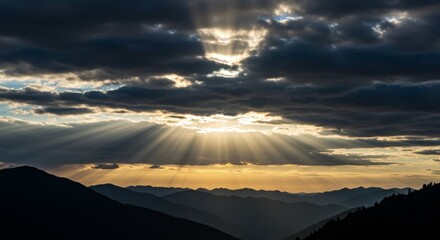 Sunbeam Breaking Through Dramatic Clouds Over Mountain Peaks
