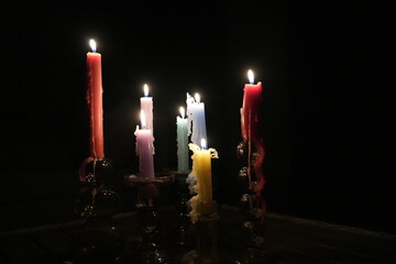 Candle flames in darkness reflecting occult energy, sacred rituals, mystic traditions, hidden...