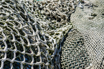 Detail view of weathered fishing nets with visible knots and intricate mesh pattern, perfect for...