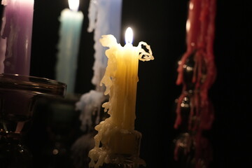 Candle flames in darkness reflecting occult energy, sacred rituals, mystic traditions, hidden...