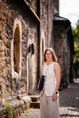 Fototapeta premium Confident Woman with Laptop Bag on Historic Cobblestone Street