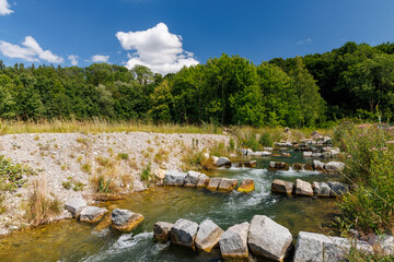 Artificial fish ladder in a river stream, surrounded by forest and blue sky, illustrating ecological river restoration and sustainable water infrastructure